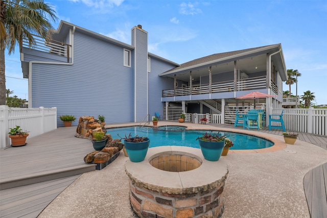 view of swimming pool with an outdoor fire pit, a patio area, a wooden deck, and an in ground hot tub