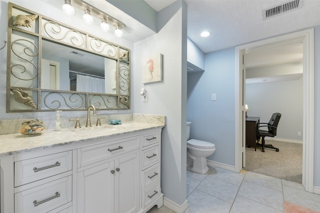 bathroom with tile patterned floors, toilet, a textured ceiling, and vanity