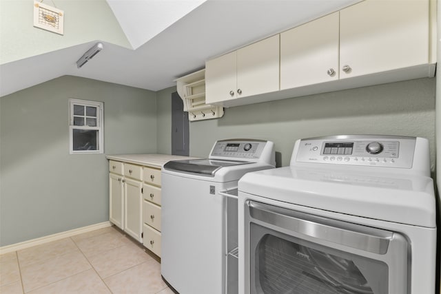 laundry room with cabinets, washing machine and dryer, and light tile patterned flooring