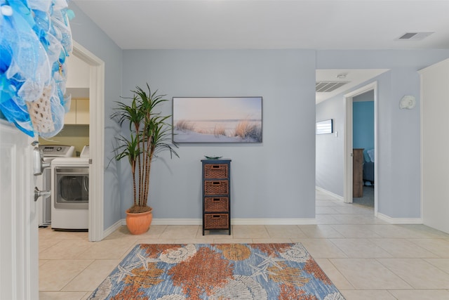 interior space with light tile patterned flooring and washer and dryer