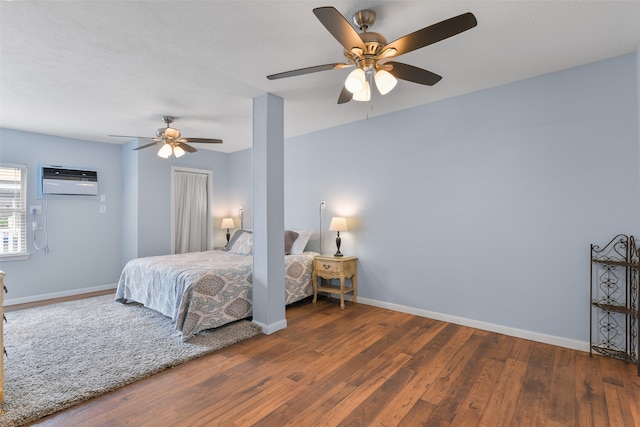 bedroom with ceiling fan, an AC wall unit, and dark hardwood / wood-style flooring