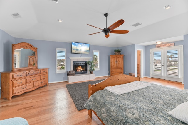 bedroom with multiple windows, ceiling fan, access to outside, and light hardwood / wood-style flooring