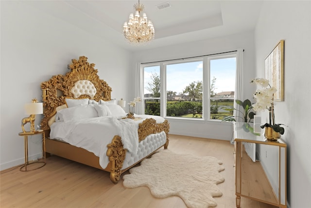 bedroom featuring wood-type flooring and an inviting chandelier