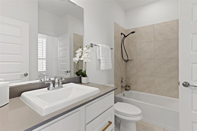 full bathroom with tiled shower / bath, vanity, toilet, and tile patterned floors