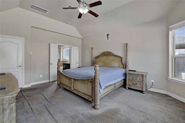 carpeted bedroom featuring ceiling fan, ensuite bathroom, and vaulted ceiling