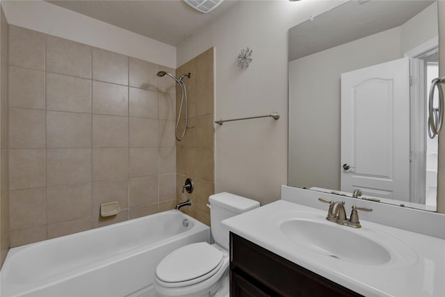 full bathroom featuring vanity, tiled shower / bath combo, and toilet