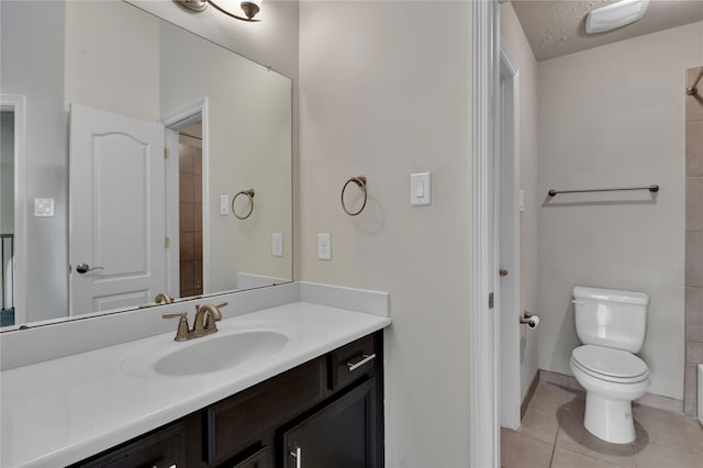 bathroom with a textured ceiling, tile patterned flooring, vanity, and toilet