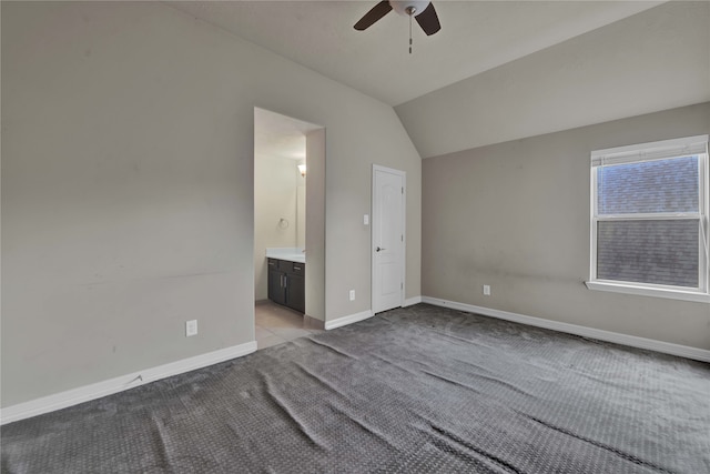 unfurnished bedroom with light carpet, connected bathroom, vaulted ceiling, and ceiling fan