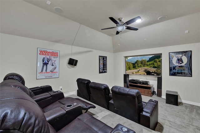 home theater with vaulted ceiling, ceiling fan, and light colored carpet