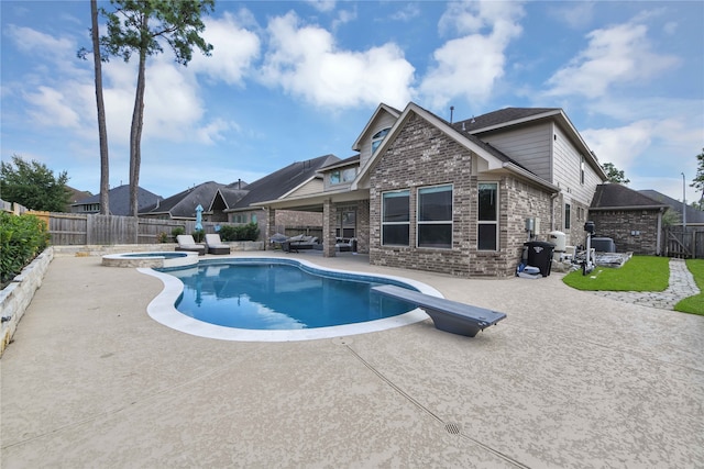 view of pool featuring a diving board, an in ground hot tub, and a patio area