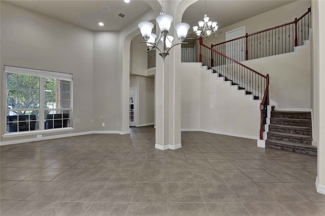 unfurnished living room featuring a notable chandelier, a high ceiling, and light tile patterned floors