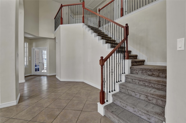 stairs featuring a towering ceiling and tile patterned floors