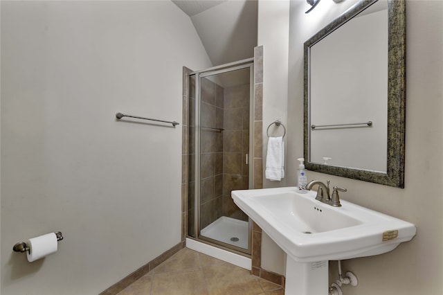 bathroom featuring walk in shower, vaulted ceiling, and tile patterned floors