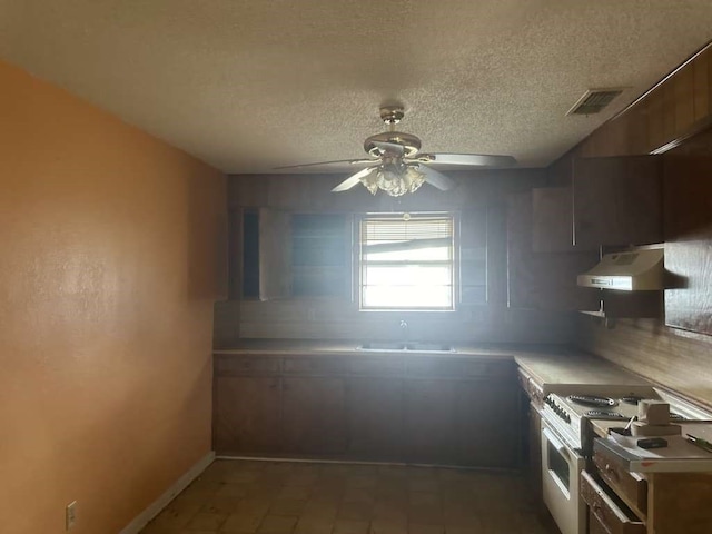 kitchen featuring a textured ceiling, stainless steel electric stove, sink, ceiling fan, and extractor fan