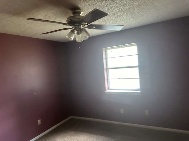 empty room featuring a textured ceiling, ceiling fan, and carpet flooring