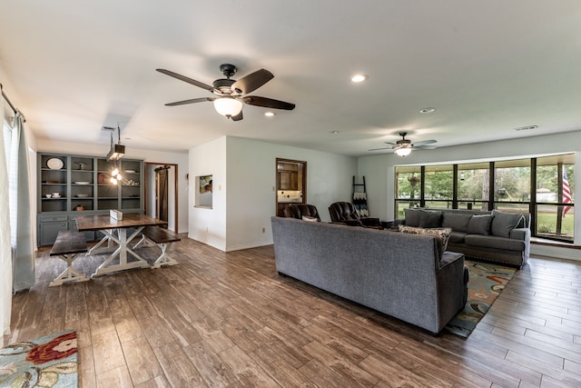 living room featuring ceiling fan and dark hardwood / wood-style floors