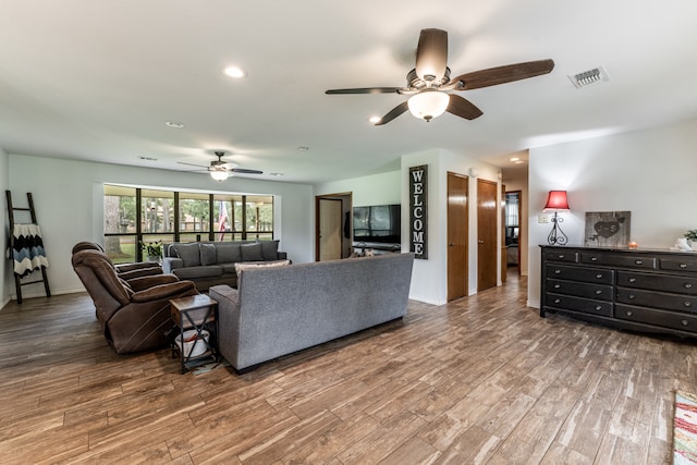 living room featuring ceiling fan and hardwood / wood-style floors