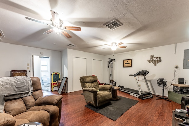 living room featuring a textured ceiling, electric panel, ceiling fan, and dark hardwood / wood-style floors