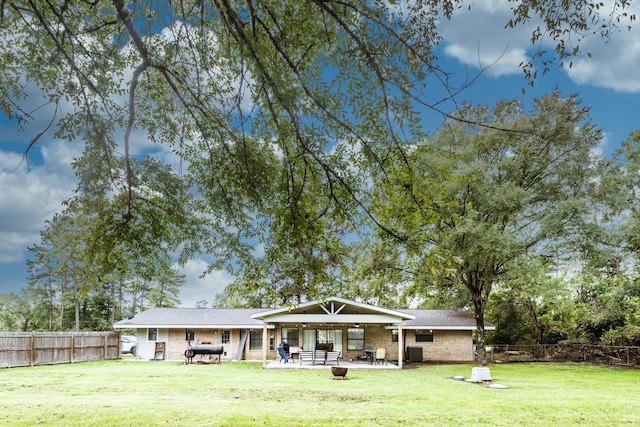 rear view of property featuring a patio area, a yard, and cooling unit