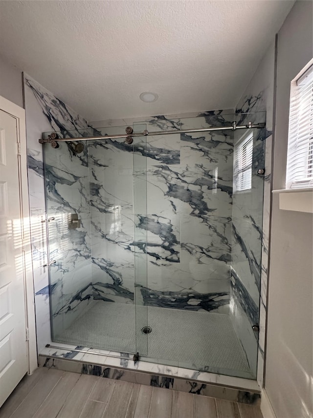 bathroom featuring walk in shower and a textured ceiling