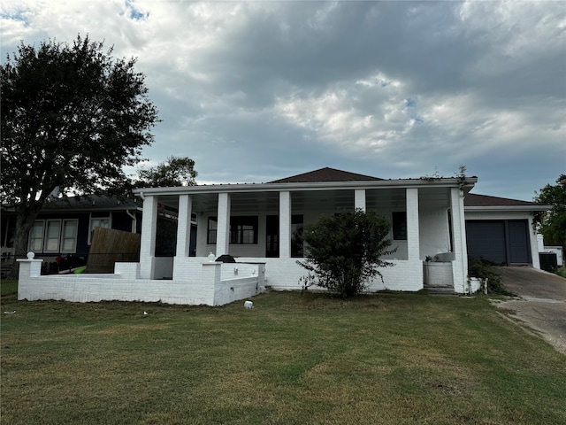 view of front of house with a garage, covered porch, and a front yard