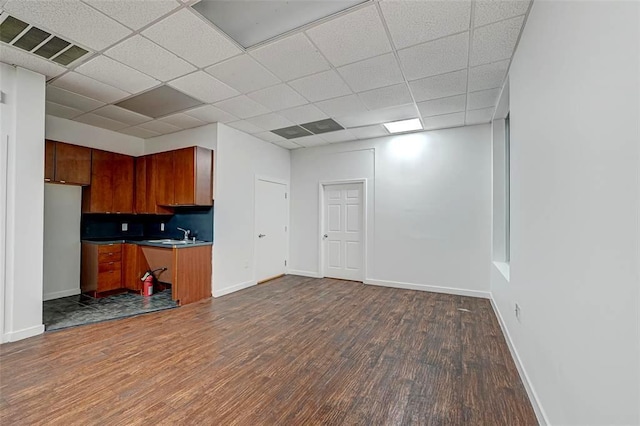 9788 Clarewood Dr Unit 201, Houston, TX 77036 - kitchen with dark wood finished floors, brown cabinetry, baseboards, a drop ceiling, and a sink