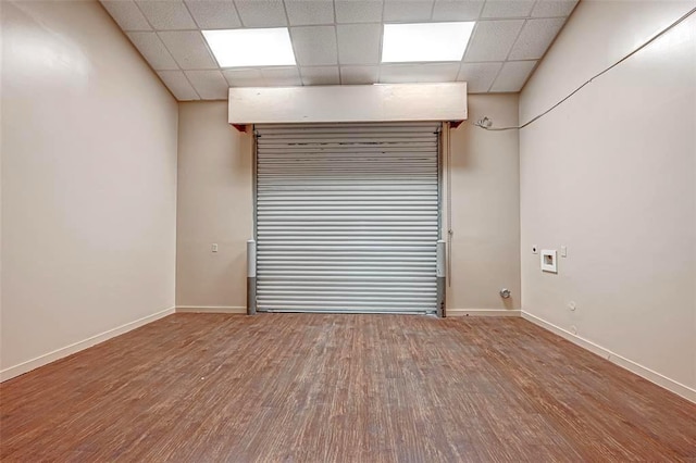 9788 Clarewood Dr Unit 201, Houston, TX 77036 - empty room featuring a drop ceiling, wood finished floors, and baseboards
