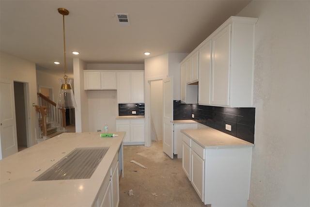 kitchen featuring light countertops, backsplash, white cabinetry, and pendant lighting