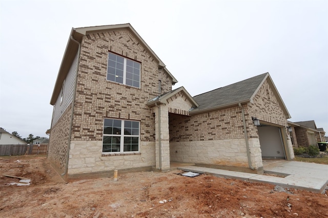 view of front of property featuring a garage, concrete driveway, and brick siding