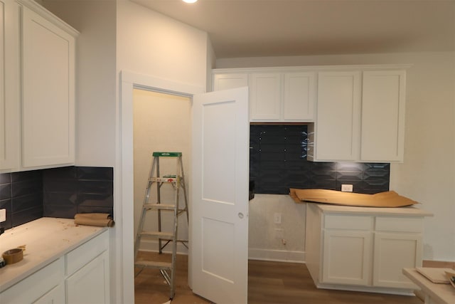 kitchen featuring tasteful backsplash, dark wood finished floors, and white cabinets