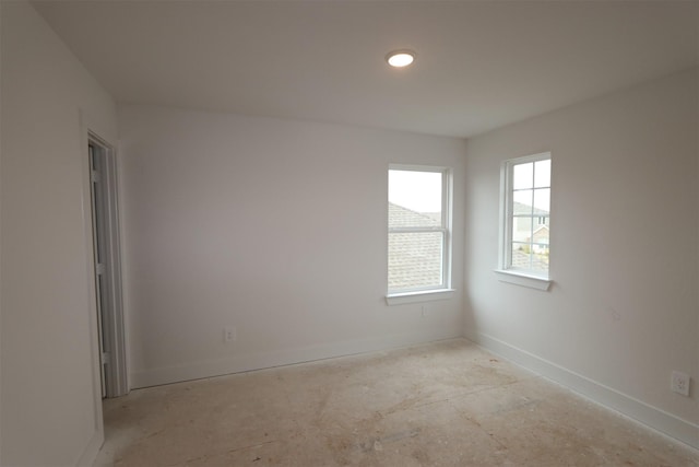 unfurnished room with baseboards