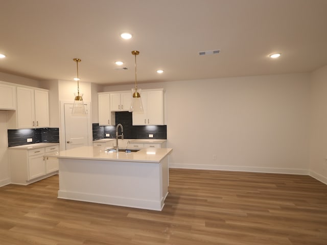 234 Augustine Way, Magnolia, TX 77354 - kitchen with tasteful backsplash, white cabinets, light wood-style flooring, and recessed lighting