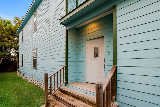 property entrance featuring a lawn