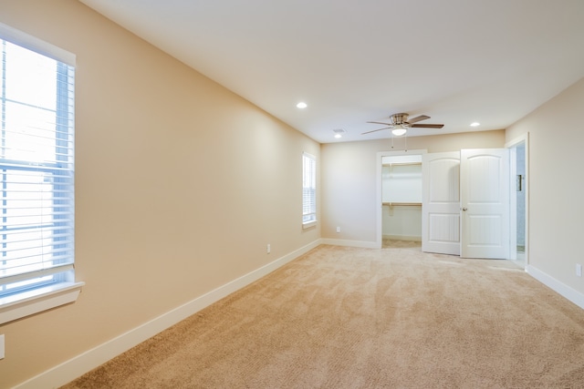 interior space with ceiling fan and light carpet