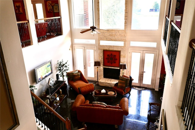 living room with a high ceiling, ceiling fan, french doors, and a wealth of natural light