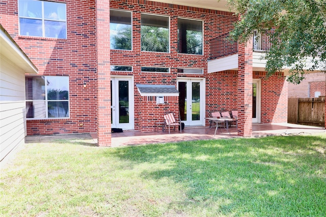 rear view of house with a lawn and a patio