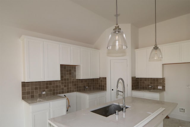 kitchen with sink, white cabinets, and decorative light fixtures