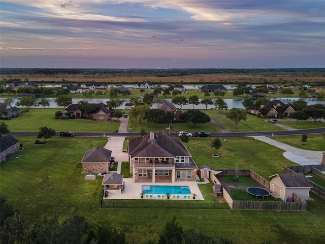 aerial view at dusk featuring a water view