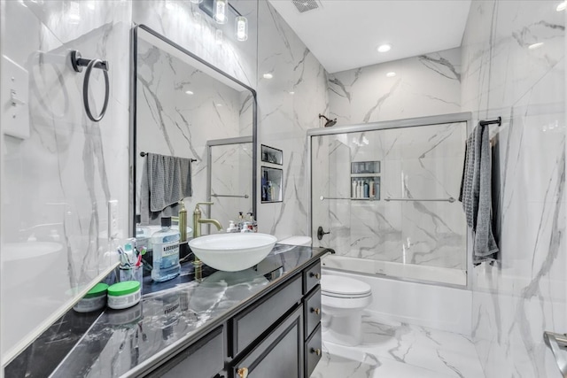 full bathroom with vanity, bath / shower combo with glass door, and toilet