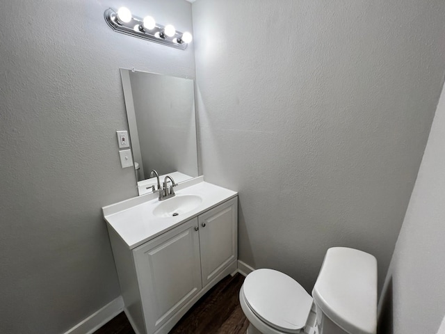 bathroom featuring vanity, toilet, and hardwood / wood-style floors