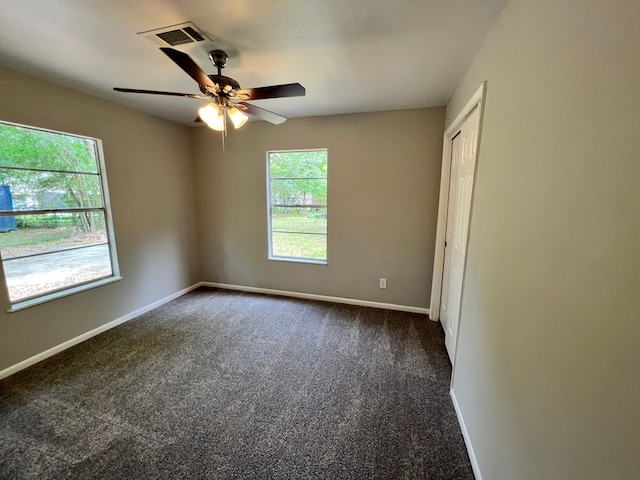 empty room featuring dark colored carpet and ceiling fan