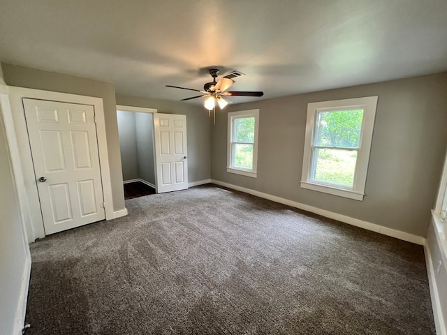 unfurnished bedroom featuring dark carpet and ceiling fan