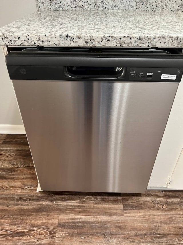 interior details featuring white cabinets, dark hardwood / wood-style floors, and stainless steel dishwasher