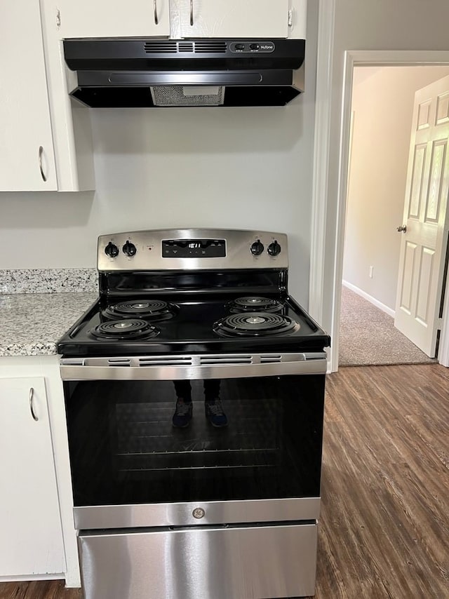 kitchen with range hood, white cabinets, and electric stove