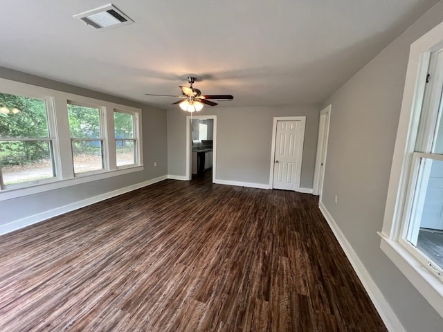 unfurnished living room with dark wood-type flooring and ceiling fan