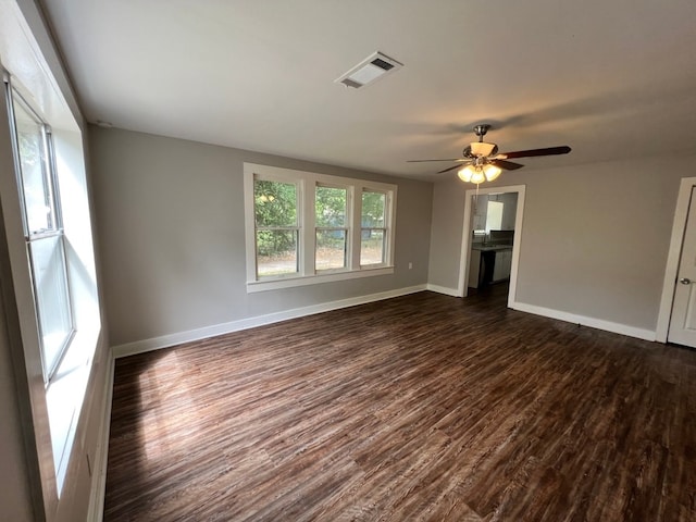 empty room with ceiling fan and dark hardwood / wood-style flooring