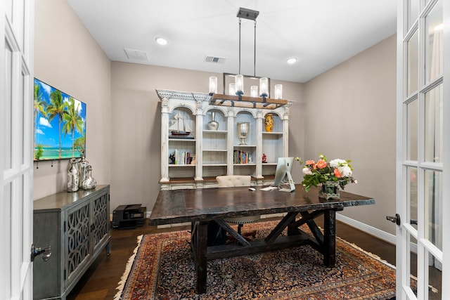 office area with dark hardwood / wood-style flooring and a notable chandelier