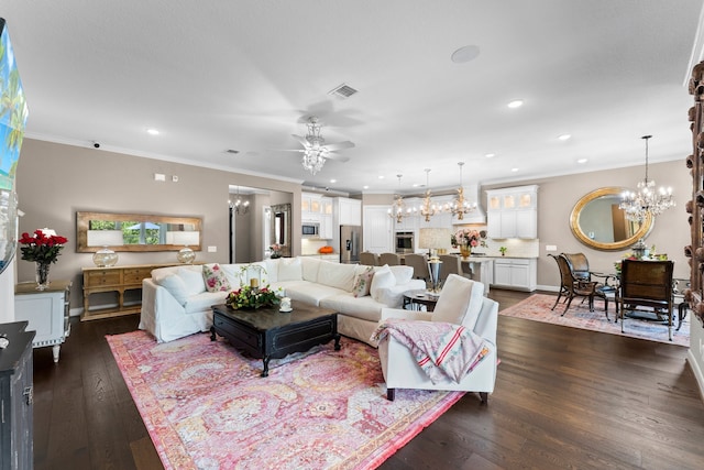 living room featuring ceiling fan with notable chandelier, dark hardwood / wood-style floors, and crown molding