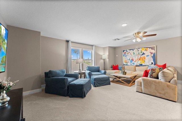 living room with ceiling fan, carpet flooring, and a textured ceiling