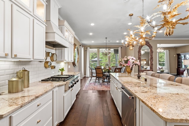 kitchen with a notable chandelier, white cabinetry, plenty of natural light, and hanging light fixtures